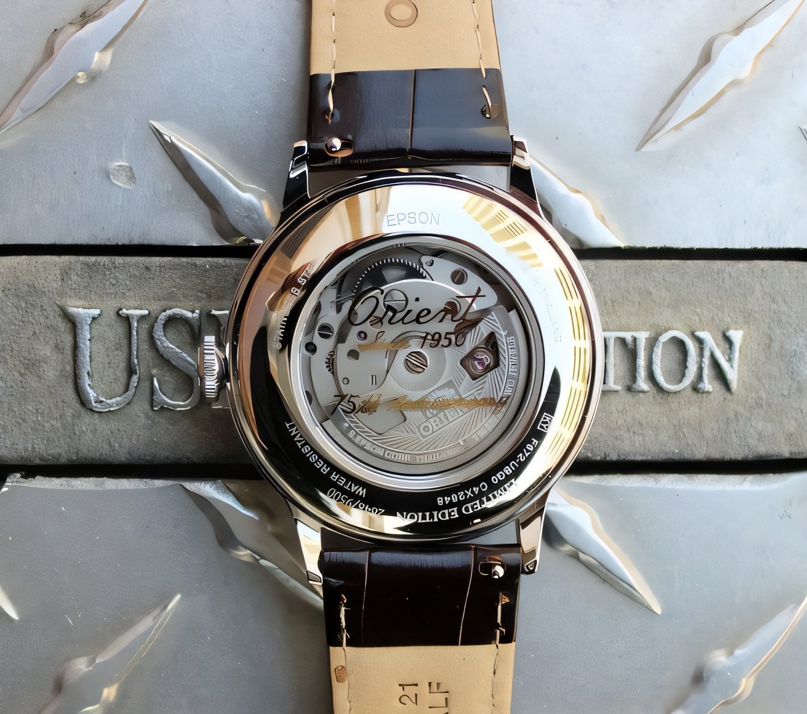 Exhibition caseback of the Orient Bambino 75th with 75th anniversary branding on the rotor
