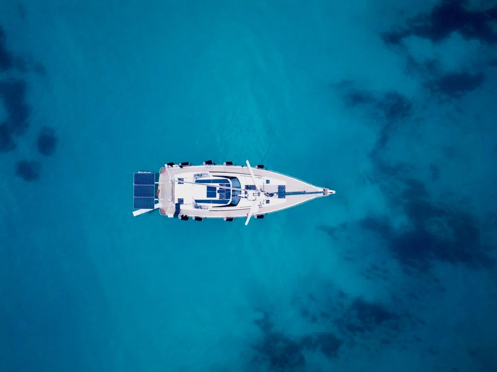 Aerial view of a white sailboat on turquoise water